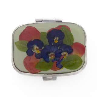 Pastillero con pensamientos, pétalos de rosas y hojas sivestres